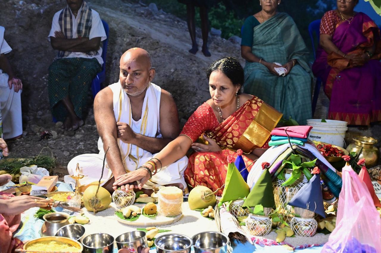 శంకుస్థాపన పూజలో పూజా సామగ్రి ముందు కూర్చున్న భక్తులు